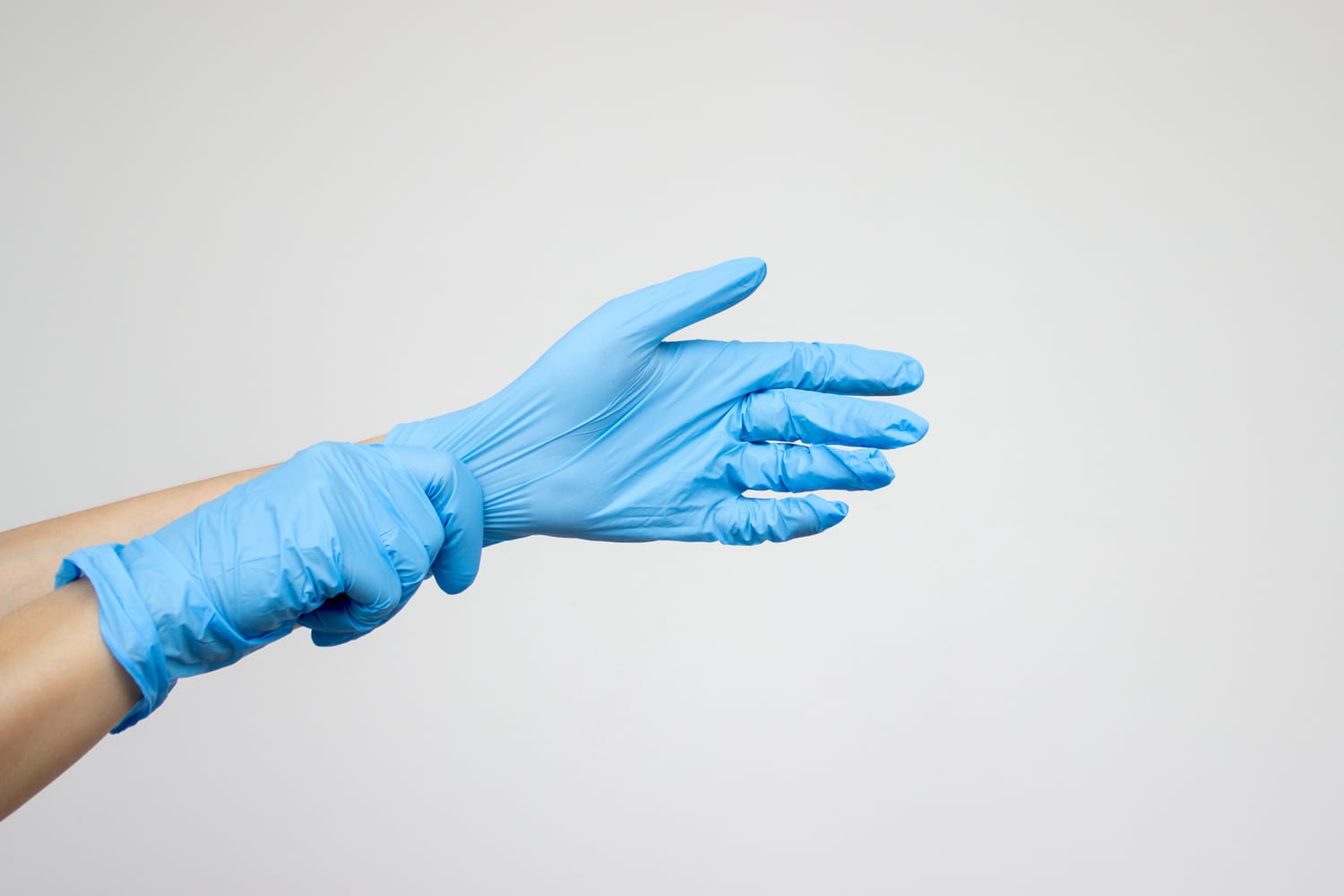 Pflegekraft zieht medizinische Einmalhandschuhe an